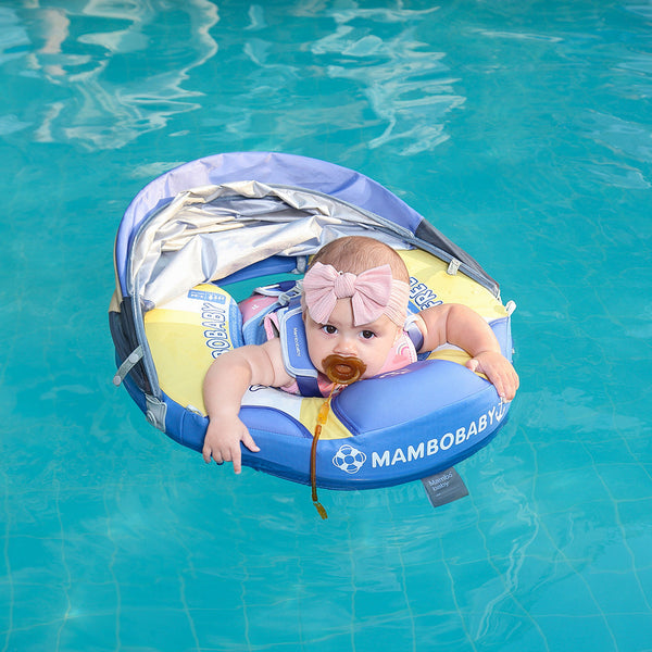 Ayuda para nadar Mambobaby™ con capota solar y arnés azul y amarillo, bebé en el agua.